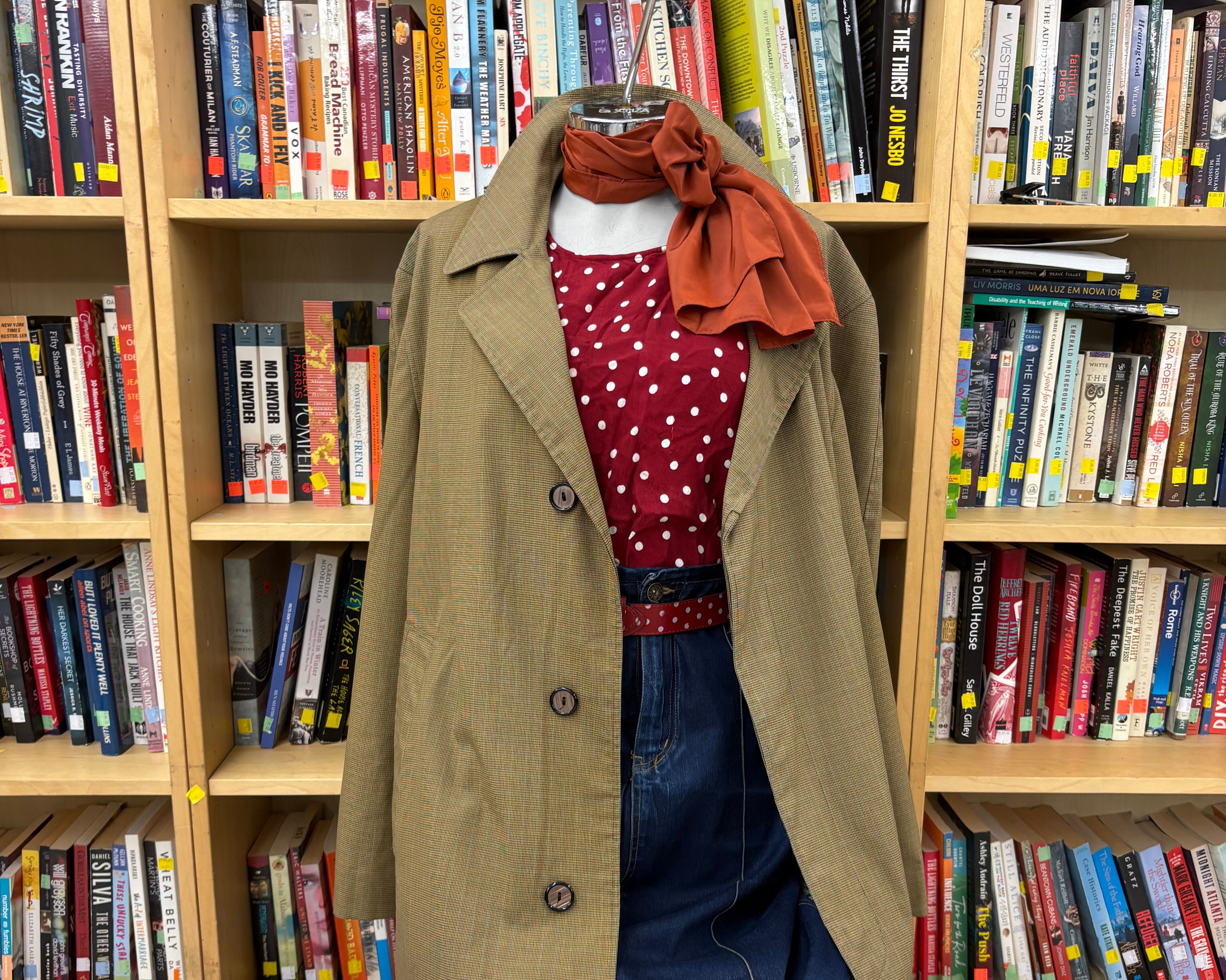 Polka dot top with fall coat over top, denim on the bottom of the mannequin