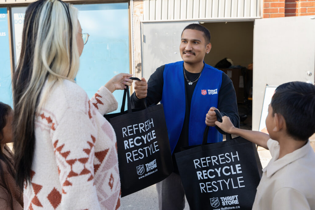 Women and child Handing over bags of donations to a thrift associate