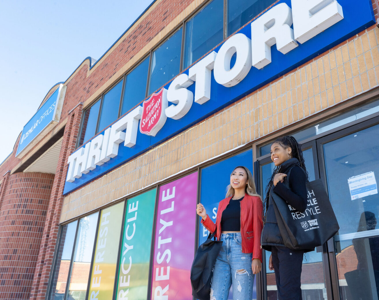 Two women standing in front of Salvation Army Thrift Store storefront