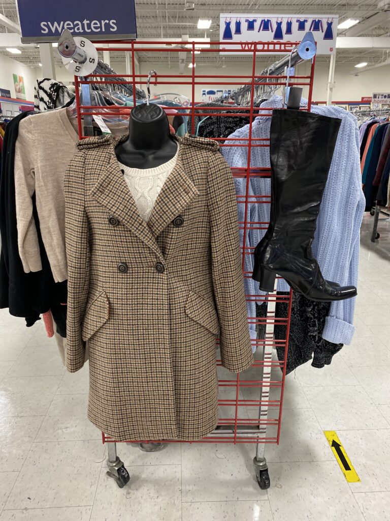 brown plaid trench coat on the end of an aisle rack