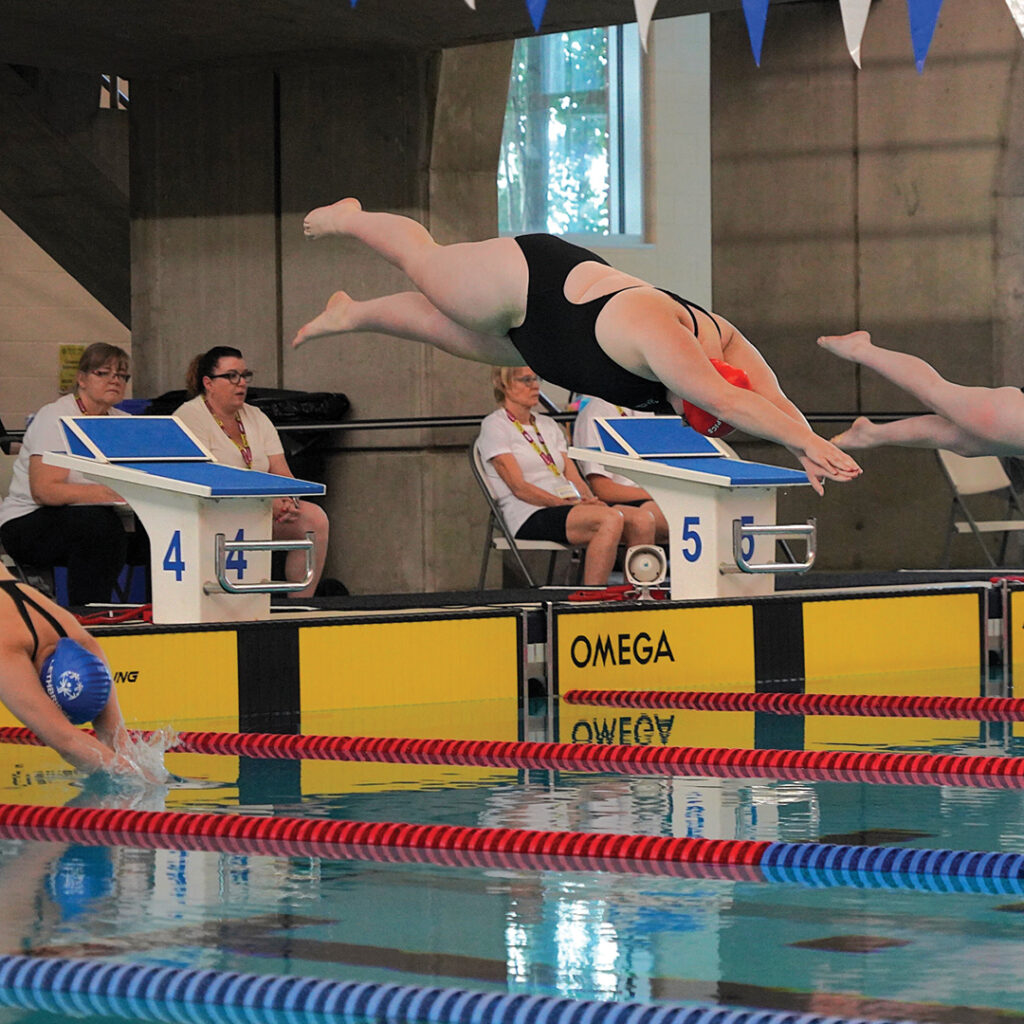 Casey mid dive into a swimming pool