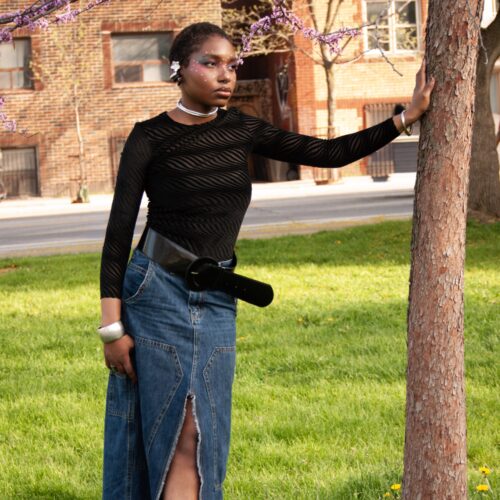 Our collaborator Kendra wearing a black sheer layered longsleeve, jean maxi skirt outside by a tree square