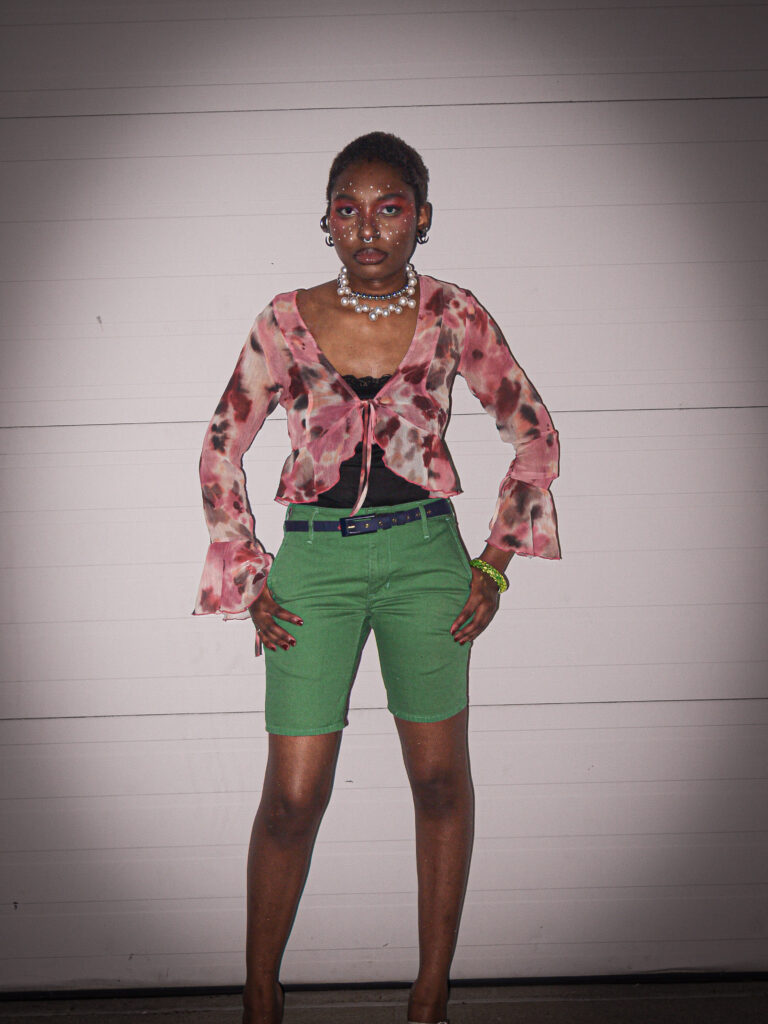 Our collaborator Kendra wearing green jorts and a pink flowy blouse
