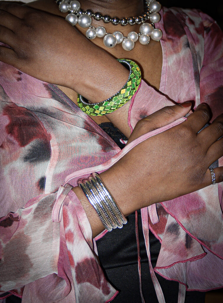 Our collaborator Kendra wearing a pink flowy blouse and green bracelet