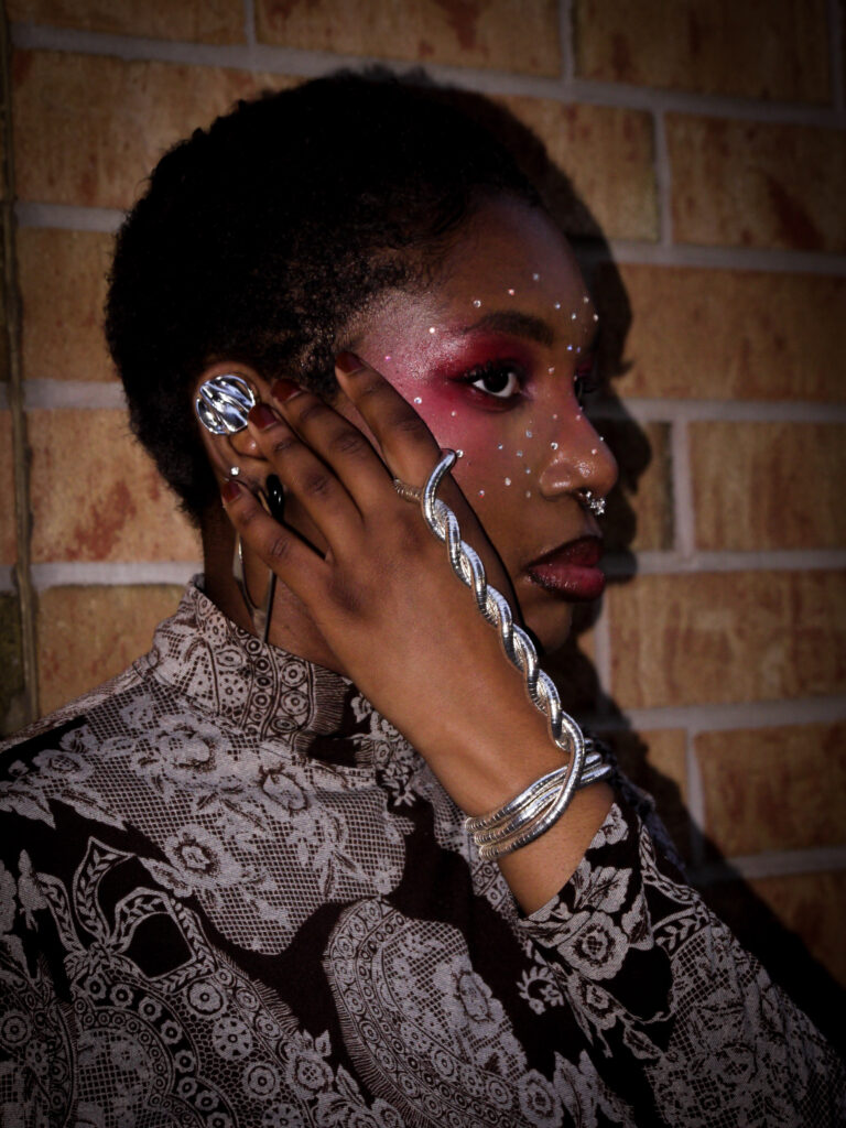 Our collaborator Kendra wearing a grey and black blouse and silver bracelet